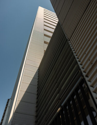 exterior facade of a modern skyscraper, likely highlighting its architectural details and sun-shading mechanisms in Bucharest Romania