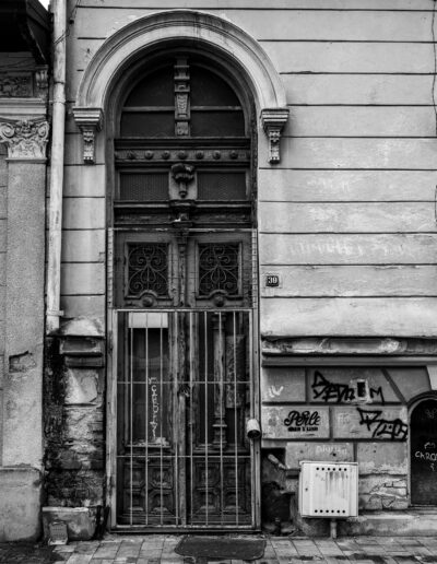 antique, arched wooden door secured behind a metal security gate in Bucharest Romania